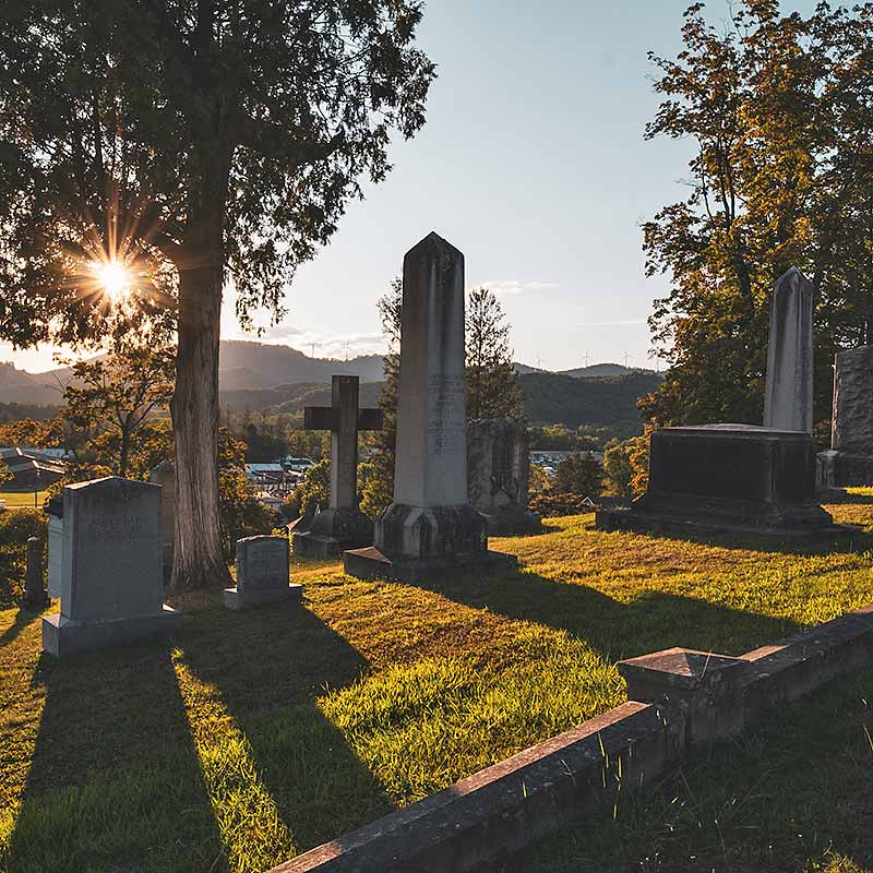 Cemetery monuments and headstones at sunrise.